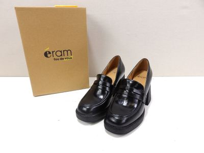 the black loafer is next to a box and a pair of shoes