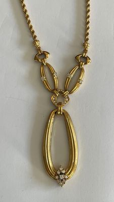 an image of a gold necklace on a white surface