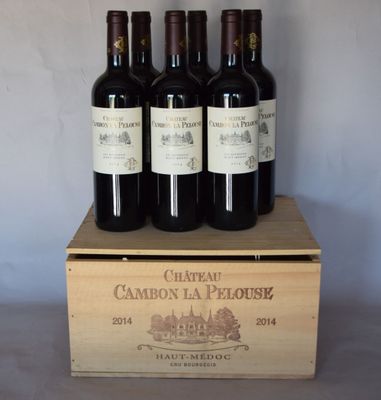 trois bouteilles de vin se trouvent dans une caisse en bois posée sur une table
