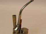 a brass pipe and a brass box on a white surface