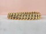 a close up of a gold bracelet on a marble surface