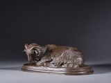 a statue of a sheep laying down on a pedestal