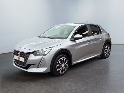 Une voiture argentée est garée dans une pièce aux murs blancs.