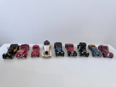 un groupe de petites voitures posées sur une table blanche