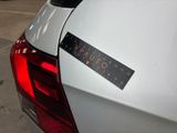 a sticker on the back of a white car