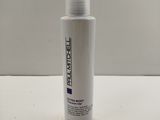 un flacon de produit capillaire Paul Mitchell posé sur une table