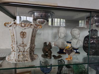 a glass display case with a lot of vases and figurines in it