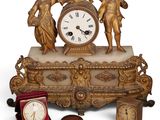 une horloge en or posée sur une table, à côté d'autres objets
