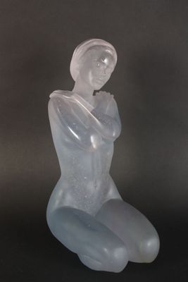 sculpture of a woman sitting on her knees with her hands on her knees