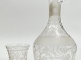 a glass decanter and a glass goblet sitting next to each other