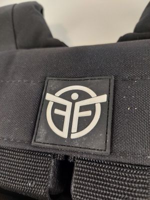 un gros plan d'un sac à dos noir orné d'un logo blanc