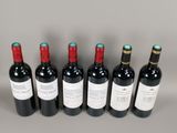 six bottles of wine are lined up in a row on a table