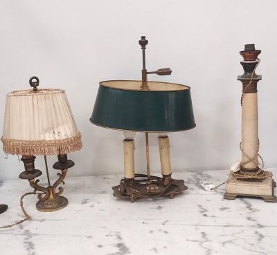 trois lampes et un abat-jour posés sur une table en marbre