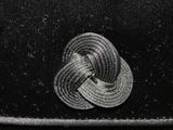 a close up of a black hat with a knot on it