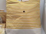 yellow and white striped tote bag next to two bags of food
