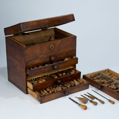 a small wooden box with a drawer full of tools