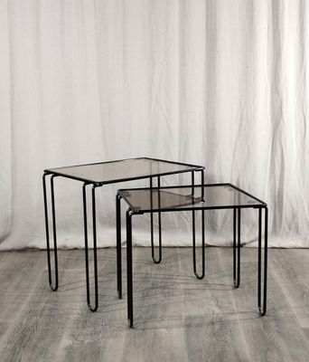 un ensemble de trois tables gigognes en verre posées sur un parquet