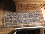 un tapis posé à même le sol, à côté d'une armoire en bois