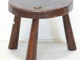 a small wooden stool with two legs on a white floor