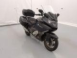 a black motorcycle parked in a room with a white wall