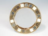 a gold plate with a mirror on it on a table