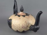 a black and white teapot with two birds on it