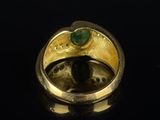 an image of a gold ring with a green stone in the middle