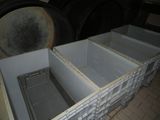 a white box with a metal lid sitting on a brick floor