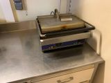 plan de travail en acier inoxydable dans une cuisine professionnelle, sur lequel est posée une friteuse
