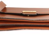 a wallet with a pen on top of it on a white surface