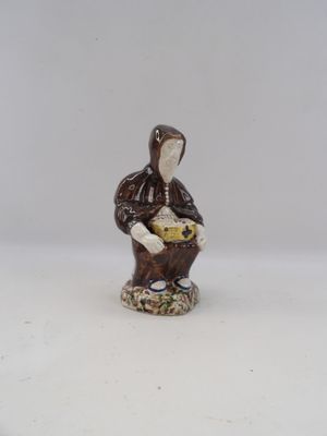 a figurine of a woman holding a basket of food