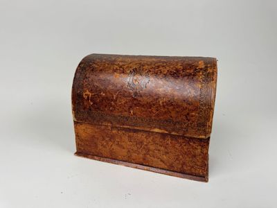 une vieille boîte en bois posée sur une surface blanche