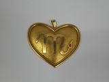 a gold heart shaped locke with the letter m on it