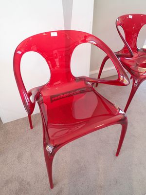 deux chaises en plastique rouges placées l'une à côté de l'autre dans une pièce