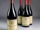 four bottles of wine are lined up on a table