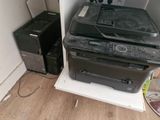 a black printer sitting on top of a white shelf next to a black printer