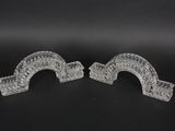 pair of clear glass bookends on a black background