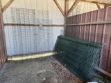 a chicken in a cage next to a metal fence