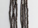 a close up of a strand of beads on a white surface
