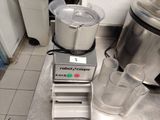 un mixeur posé par terre à côté d'un verre d'eau