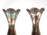 two silver vases that are sitting on a table