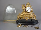 une horloge placée sous un dôme de verre sur une table