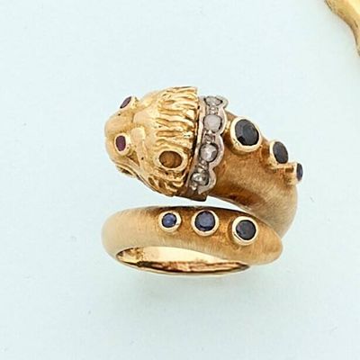 a gold ring with a snake on it and a diamond ring on the side