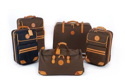 quatre bagages posés les uns à côté des autres sur une surface blanche