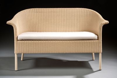 an image of a wicker bench with a white cushion on it