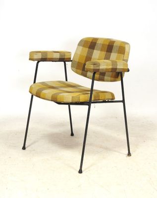 une image représentant une chaise dont l'assise est recouverte d'un tissu à carreaux jaunes et marron