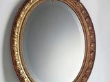 a gold mirror hanging on the wall above a sink