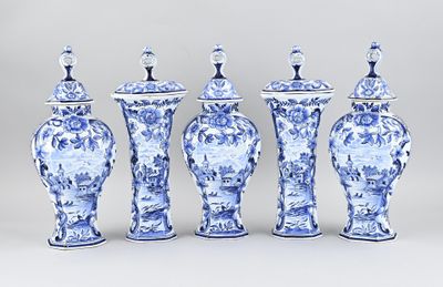 quatre vases bleus et blancs sont alignés sur un fond gris