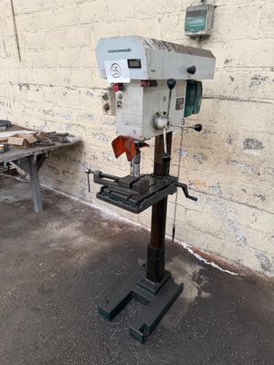 a machine that is sitting on a stand in front of a brick wall