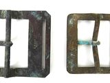 two metal buckles that are on a white surface
